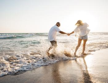 couple walking through the surf on the beach