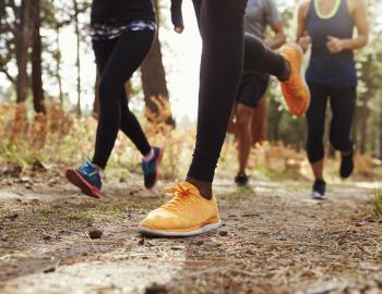 close up of joggers' feet running on a trail