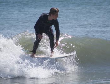 A surfer catches a wave on an April day on the Outer Banks.