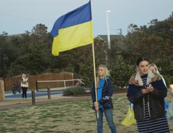 An Outer Banks Ukrainian resident carries the Ukrainian flag to the stage at Dowdy Park.