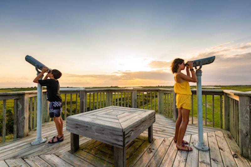 two kids looking through view finders at a nature preserve in the outer banks