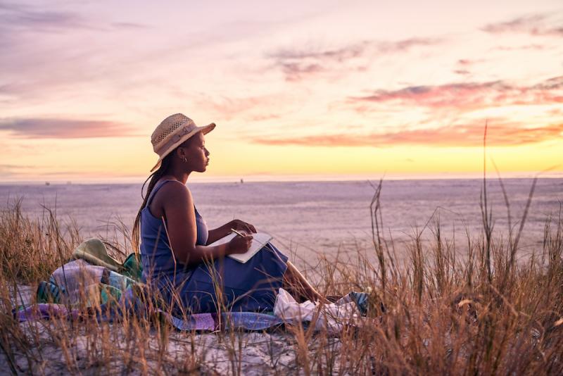 woman journaling at the beach