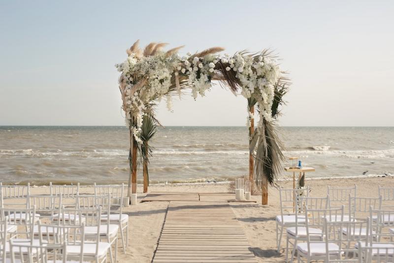 wedding arch and chairs on beach