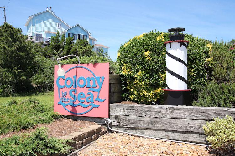 colony by the sea sign and lighthouse
