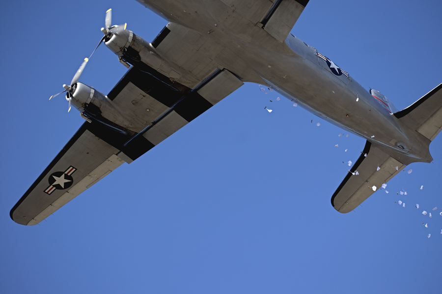 Candy parachutes float to waiting children as the Candy Bomber flies overhead.