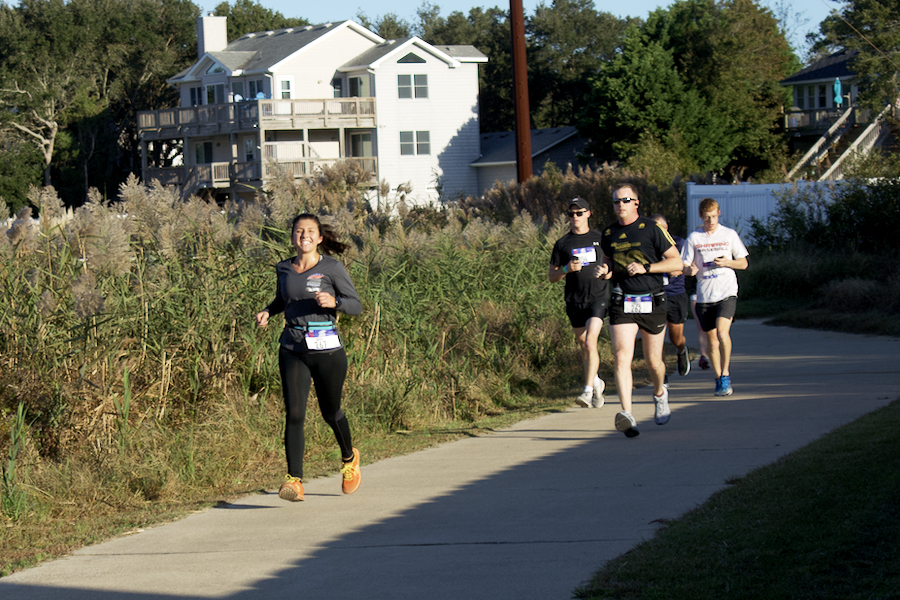 Runners competing in the 2019 Outer Banks Marathon run past Kitty Hawk Bay.