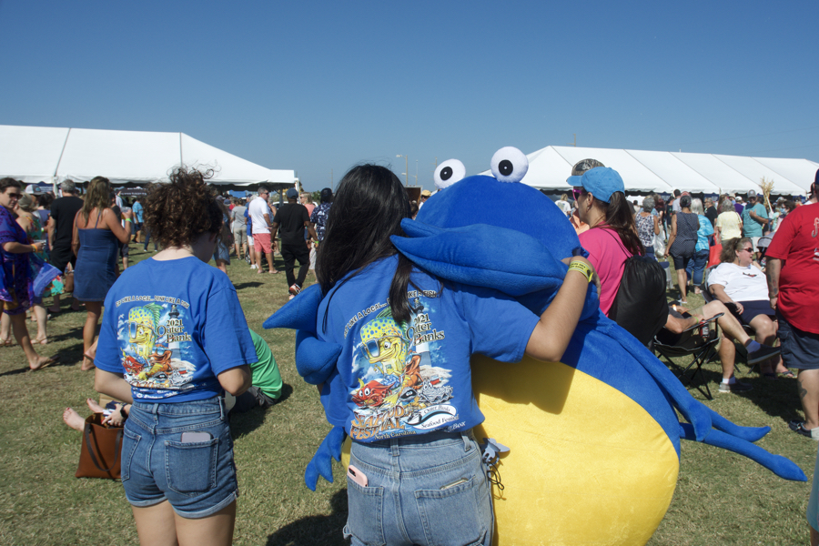 Outer Banks Seafood Fest mascot gives volunteer a hug.