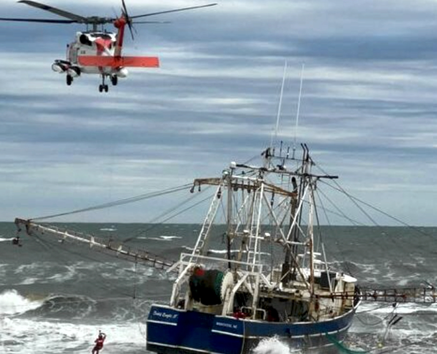Coast Guard helicopter pulls on of the four crewmen from Bald Eagle II.