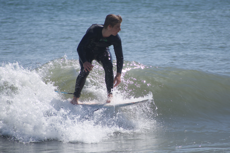 A surfer catches a wave on an April day on the Outer Banks.
