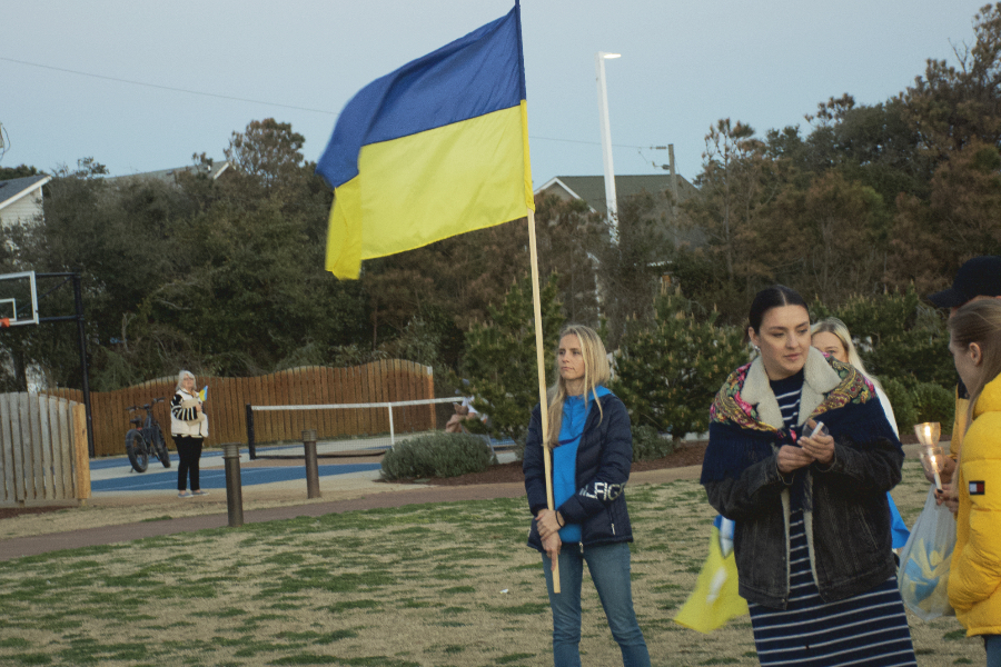 An Outer Banks Ukrainian resident carries the Ukrainian flag to the stage at Dowdy Park.
