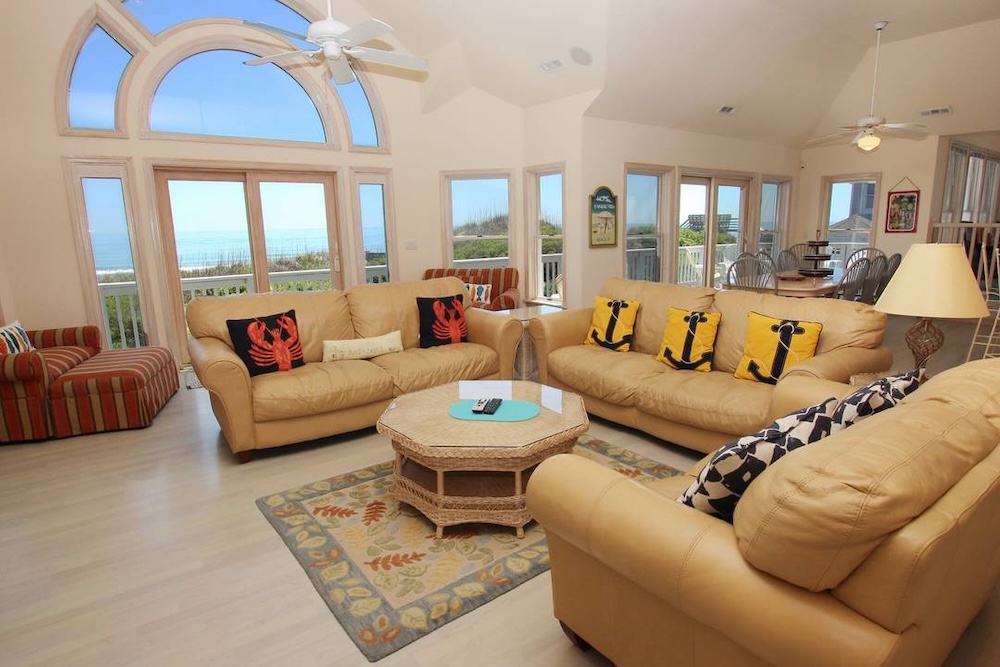 Living room view of an Outer Banks vacation rental showing couch, and dining area