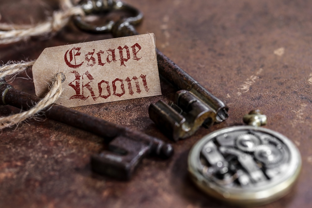 old skeleton keys on a table tied with twine and a tag that says escape room
