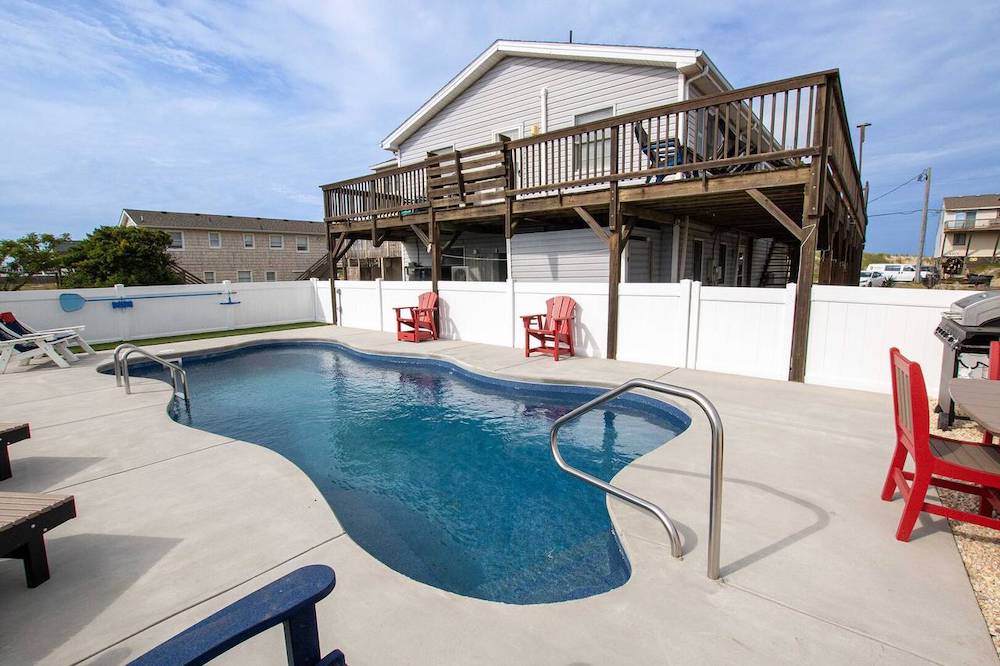 Exterior view of home showing in ground pool and deck