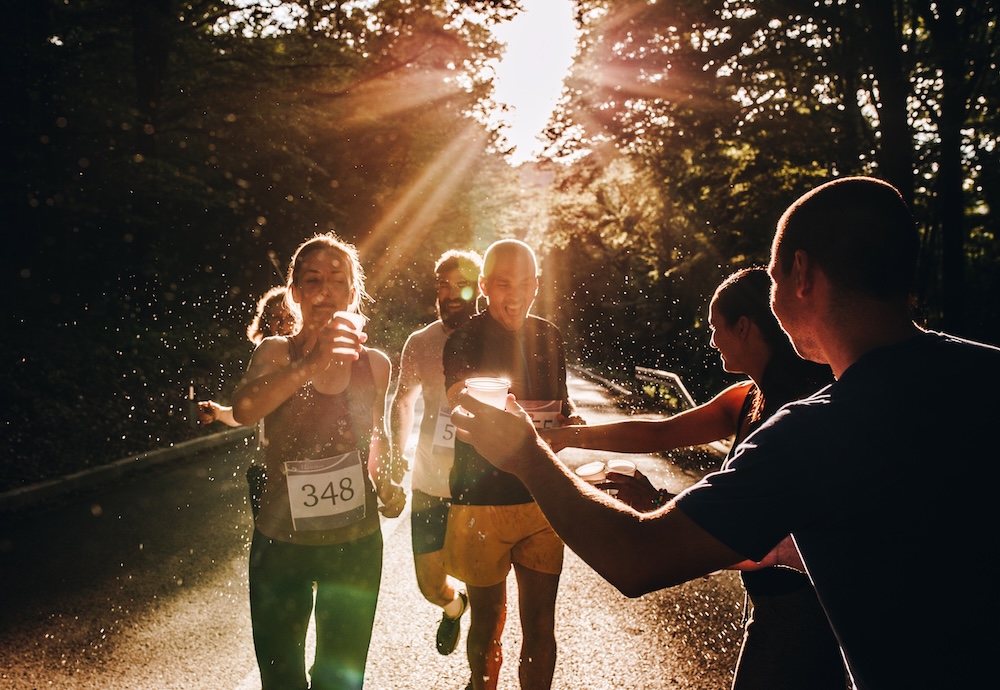 marathon runners passing by a water station